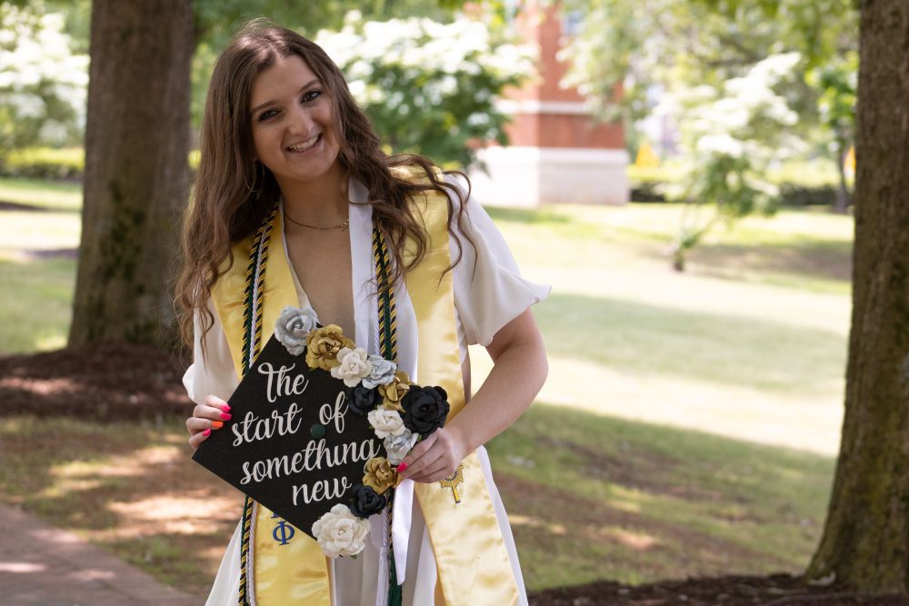 Jordan Badenhop poses with cap that says 'The Start of Something New"