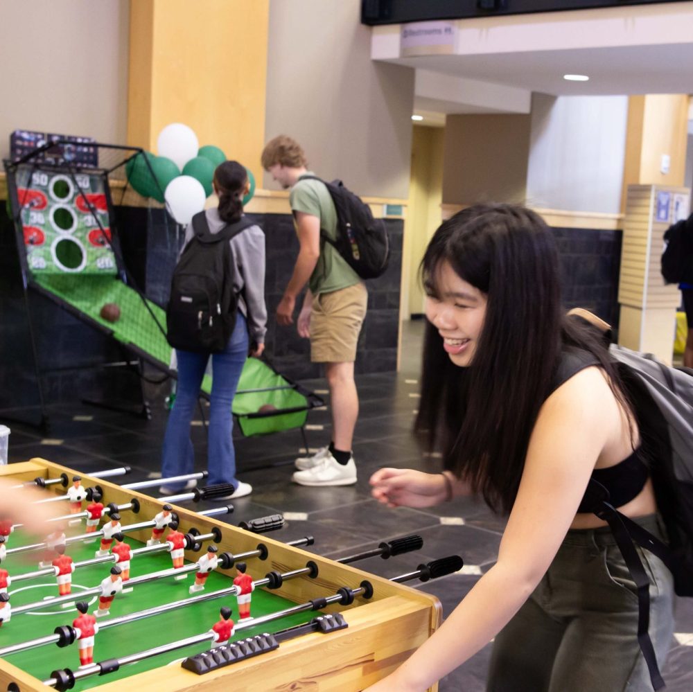 A student plays foosball in the Student Union just outside Charlotte Barnes & Noble