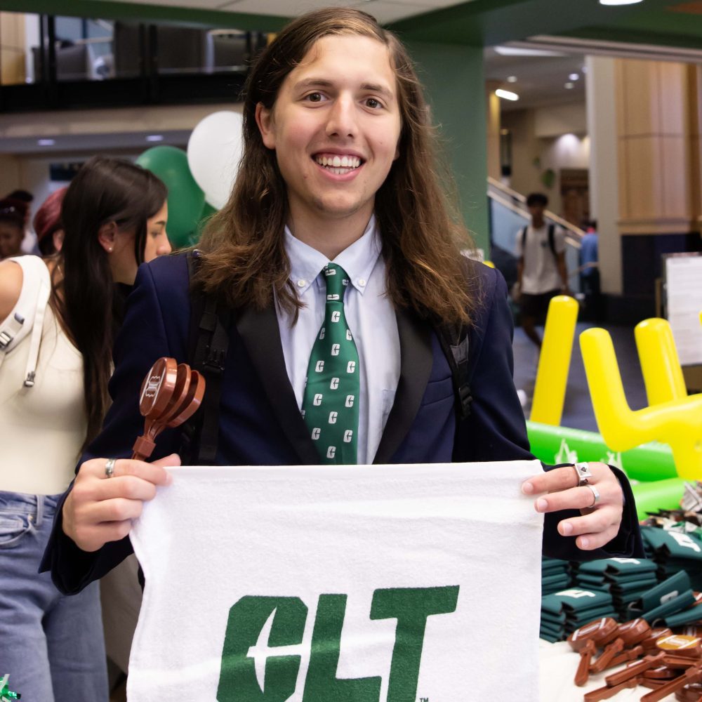 Student with green Charlotte necktie poses with CLT rally towel in Charlotte Barnes & Noble