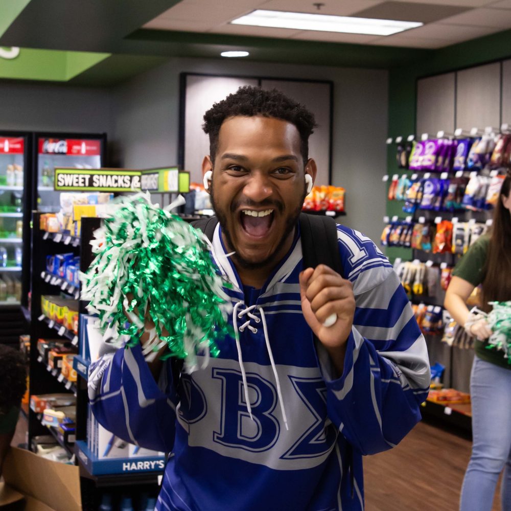 Excited student holds pom pom in Charlotte Barnes & Noble