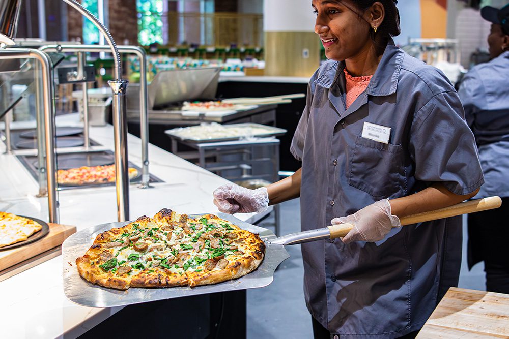 Social 704 chef pulls pizza out of oven