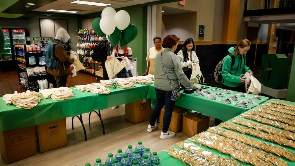 Rachel Skipworth organizes the giveaway items on the table as students enter the bookstore